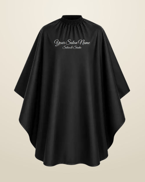 Embroidered black salon cape with a salon name stitched on it
